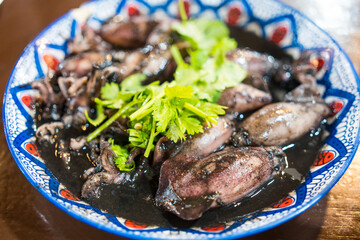 Squid in black ink sweet sauce. The taste is sweet and salty, famous menu with squid black ink