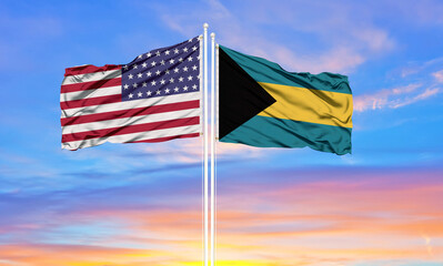 Fototapeta premium United States and Bahamas two flags on flagpoles and blue cloudy sky . Diplomacy concept, international relations