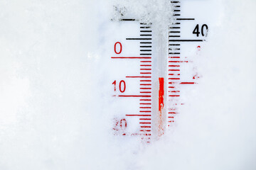 Outdoor thermometer in snow shows cold winter temperature