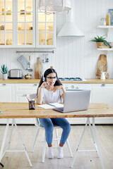 Girl in headphones and eyeglasses e-learning at home