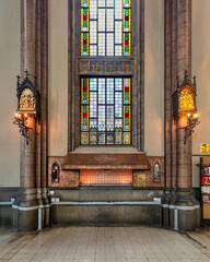 Candle stand under a beutiful stained glass windows at St. Anthony of Padua Church, one of the...