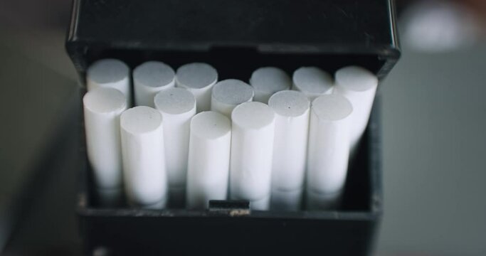 Oppening a black box package of unbranded tobacco cigarettes, slow motion, cinematic isolated shot