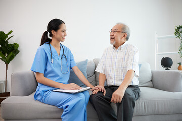 Obraz premium caregiver or nursing home holding hands and talking with senior man on sofa