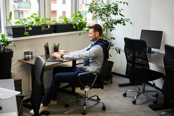 Smiling man works in a comfortable bright office
