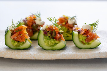 Party canapes, cucumber boats with avocado and salmon