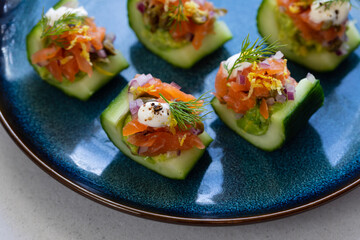 Party canapes, cucumber boats with avocado and salmon