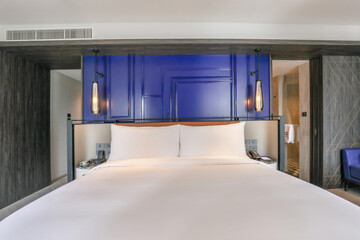 Modern hotel room with luxurious king-size bed and contemporary decor. Interior design and comfort.