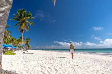 Mężczyzna na rajskiej plaży pod palmami