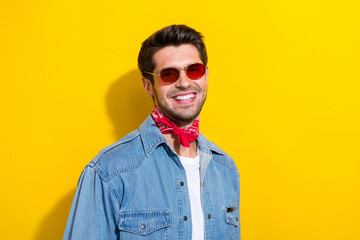 Obraz premium Portrait of toothy beaming man with bristle dressed denim shirt red scarf in sunglass smiling isolated on vibrant yellow color background