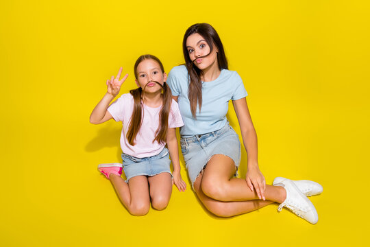 Photo of two positive girl playing game with fake curls mustache make v sign isolated over vivid color background - Powered by Adobe