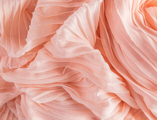 Soft air waves of peach-colored silk or chiffon fabric. Chic abstract festive background. Design...