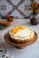 Carrot cake with cream cheese frosting and walnuts on a stone background for festive dinner. Fresh homemade carrot cake for Easter. Traditional Easter food.