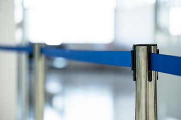 Row of steel retractable barriers with blue ropes standing on control area.VIP Zone concept.