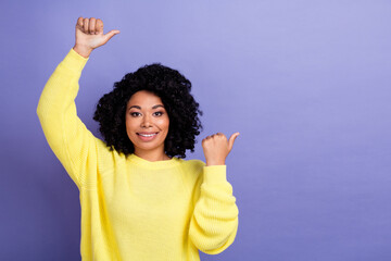 Portrait of good mood person with chevelure hair wear pullover indicating at discount empty space isolated on purple color background