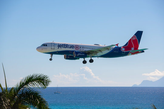 JetBlue Airways Airbus 320 flying over Maho Beach before landing on Princess Juliana International Airport SXM on Sint Maarten, Dutch Caribbean. 