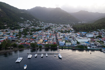 Fototapeta premium Aerial top down view of the city of Soufriere with Pitons in the background. Shot on a DJI Drone Air 2s in the Caribbean on beautiful Saint Lucia island. Colorful houses throughout the town.