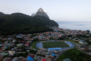 Fototapeta premium Aerial top down view of the city of Soufriere with Pitons in the background. Shot on a DJI Drone Air 2s in the Caribbean on beautiful Saint Lucia island. Colorful houses throughout the town.