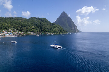 Aerial  of boat in Soufriere Bay with Gros Piton and Petit Piton on St. Lucia from Soufriere Beach.  Shot on a drone in the Caribbean on beautiful Saint Lucia island.