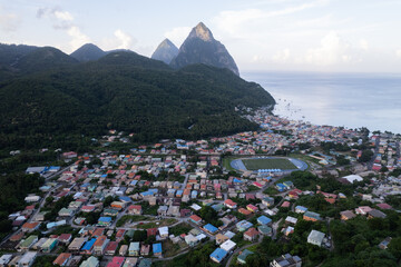 Aerial  top down view of the city of Soufriere with Pitons in the background.  Shot on a DJI Drone Air 2s in the Caribbean on beautiful Saint Lucia island.  Colorful houses throughout the town.