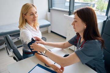 Obraz premium Practitioner preparing female for blood pressure measurement