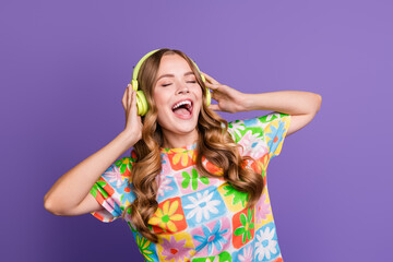 Portrait of overjoyed girl with curly hairdo touching headphones eyes closed sing favorite song...