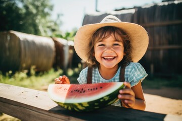 happy little kid eating watermelon on farm - obrazy, fototapety, plakaty