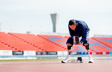 Wide shot of sport man athlete with a prosthesis on his leg prepare of the running equipment on the...