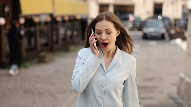 Street communication, Sidewalk talk, Mobile communication. Business lady talks on phone while walking down pathway.