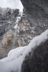 Fototapeta na wymiar Gefrorener Wasserfall in Schneebedeckter Landschaft 