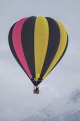 Fototapeta premium Bunter Heißluftballon in Winter Berglandschaft