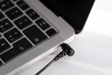 Mini jack plugged into laptop. Close up.