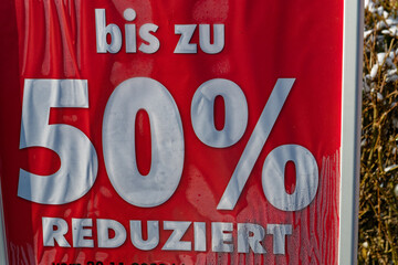 Advertising poster indicates price reductions of up to 50%