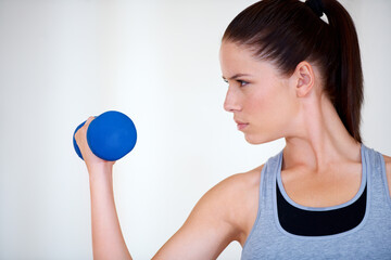 Woman, training and serious with dumbbells in studio for health wellness, fitness and weight loss with exercise. Young person, commitment and face by hand weights for tone muscle by white background