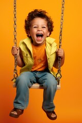 Happy smiling child boy sitting on a swing and having fun