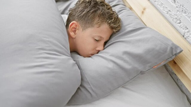 Blond boy lying on bed sleeping at bedroom