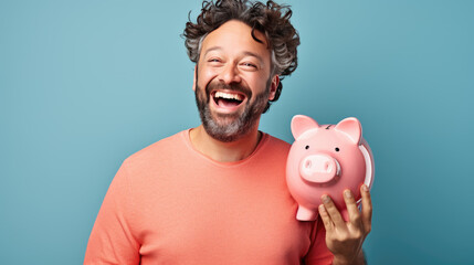 Man smiling broadly, and holding a piggybank, signifying responsible financial planning and savings. - obrazy, fototapety, plakaty