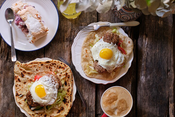 Homemade flatbread with fried egg, cheese, cutlet, salad. Rustic