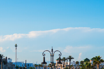 Fototapeta premium A large cloud is approaching the city with streets with lanterns and palm trees