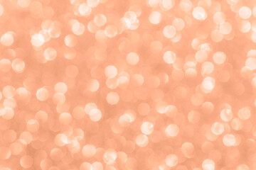 Glitter abstract bokeh background, texture. Lights festive background concept. Color of the year 2024 Peach Fuzz