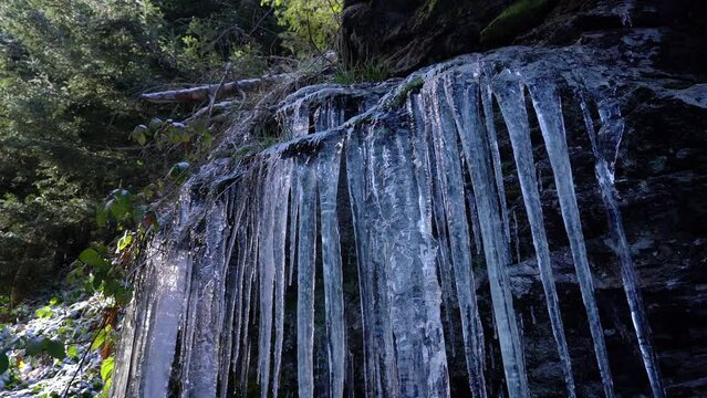 Winter Icicles on rocks in forest - (4K)