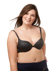 Obraz premium Portrait, smile and bra with a plus size woman in studio isolated on a white background for body positivity. Beauty, wind and a happy young model looking natural or confident in her underwear