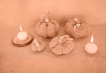Hobby background with handmade knit pumpkins and white pearl beads. DIY, craft decoration for fall...