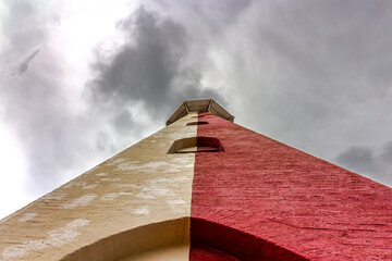 View of the old stone lighthouse tower in Georgetown, Guyana , South America against a background of a stormy sky with Cumulostratus clouds. Lighthouse - world tourism, attractions, landscape.