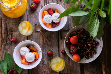 Ice cream with seasonal fruits and berries. Side view, wooden background.