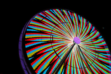 Vibrant Ferris Wheel Lights in Motion Against Night Sky Close-Up