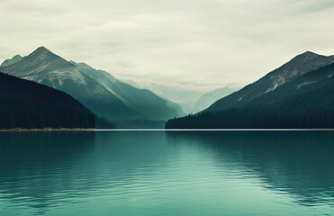 a green lake with mountains on the background - obrazy, fototapety, plakaty