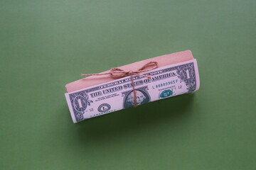 A gift wrap with a dollar bill attached to it on a green background.