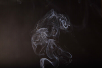 Ethereal Dance of Incense Smoke against Dark Background