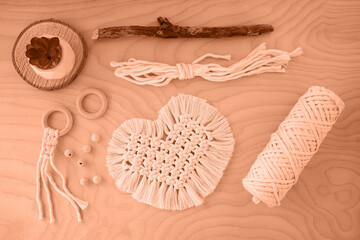 Peach fuzz is color of year 2024, tinted image. Macrame handmade napkin in the form of heart. Eco...