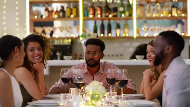 Friends in restaurant with wine, conversation and laughing at table together with chat, bonding and celebration. Fine dining, drinks and talking, men and women relax on luxury dinner date with smile.
